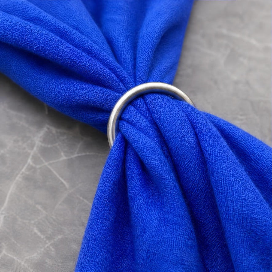 Ein blaues Kaschmirtuch liegt gerafft in einem schmalen Fingerring.